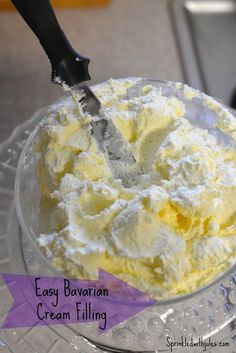 a bowl filled with ice cream sitting on top of a glass table next to a knife