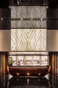 an elegant bar with marble counter tops and gold trimmings on the walls, along with large glass windows