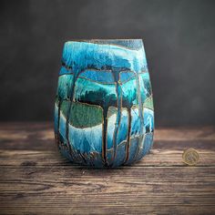 a blue vase sitting on top of a wooden table next to a quarter dollar coin