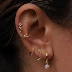 a woman's ear with three different types of piercings