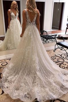 a woman standing in front of a mirror wearing a wedding dress with sequins