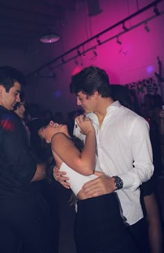 a man and woman dancing together at a party