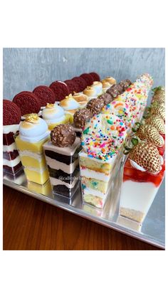 a tray filled with lots of different types of cakes and desserts on top of each other