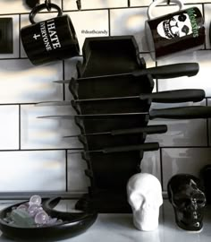 a kitchen counter topped with black pots and pans next to a white skull head