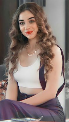 a woman with long brown hair sitting on a table wearing a white top and black skirt