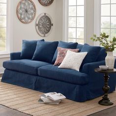 a living room with blue couches and pillows