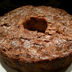 a cake sitting on top of a white plate covered in powdered sugar