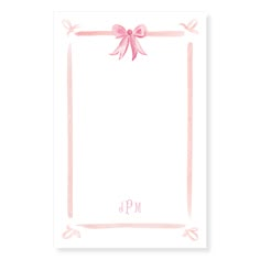 a pink card with a bow on the front and monogrammed ribbon around it