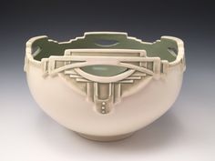 a white bowl with an eye in the center on a gray background, it appears to be made out of porcelain