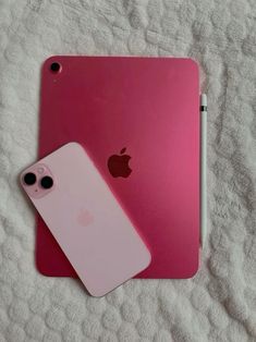 an apple ipad with a pink case next to a white pen on a bed sheet