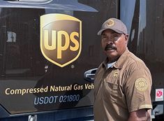 a man standing in front of a ups truck with the words compressed natural gas vein on it