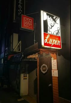 a neon sign that is on the side of a building in an alleyway at night