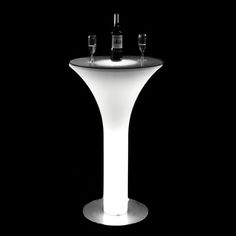 a tall white table with two wine glasses sitting on it's top and bottom