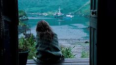 a person sitting on a bench looking out at the water