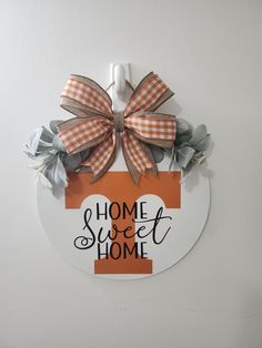 a sign that says home sweet home with a bow on the front and back of it