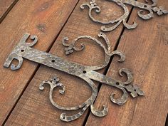 two metal brackets sitting on top of a wooden floor