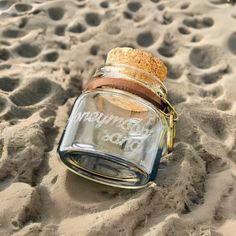 "Check out our honeymoon sand bottle, adorned with a heart charm, meticulously crafted to become a cherished memento that encapsulates the essence of your extraordinary honeymoon as a couple. This exquisite keepsake has been thoughtfully designed to capture the idyllic beauty of your beach escape, making it a perfect gift for weddings and honeymoons. It allows you to preserve tangible memories of your seaside adventures, be it sand, sea glass, pebbles, or miniature seashells. This remarkable creation serves as a timeless reminder of the magical moments you shared by the shore. DETAILS: ● Sand is not included. ● 9 ml (0.3 oz). ● Bottle size: 30х30 mm (1.2\"x1.2\").  ● Bag size: 7x9 cm (2.7\"x3.5\"). ● Materials: glass, cork, leather cord, metal charm. ● If you have any questions or special Sand Jar, Beach Jar, Wedding Time Capsule, Beach Keepsakes, Whiskey Gift Set, Wooden Card Box, Glass Pebbles, Hen Party Gifts, Personalized Whiskey