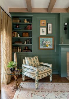 there is a chair in the room with bookshelves and pictures on the wall