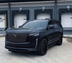 a black suv parked in front of garage doors