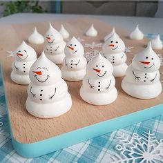 a group of snowmen sitting on top of a wooden board