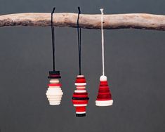 three red, white and black ornaments hanging from a tree branch