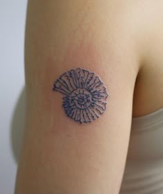 a woman's arm with a tattoo on it that has an image of a seashell