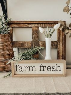 a wooden sign that says farm fresh next to some flowers in a vase on a table