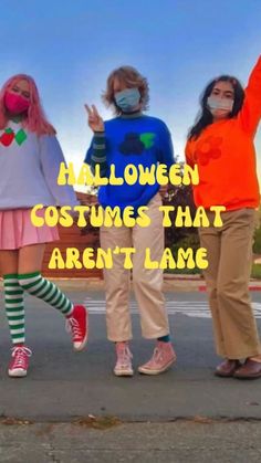 three girls wearing face masks and standing on the street with their arms in the air