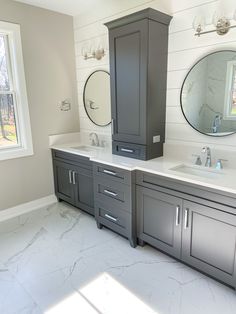 a large bathroom with two sinks, mirrors and cabinets in it's own room