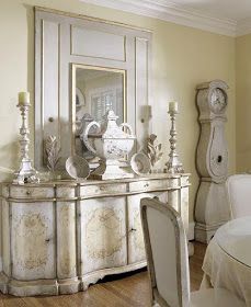 a dining room table with chairs and a mirror