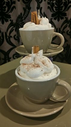 two cups filled with hot chocolate and marshmallows on top of each other