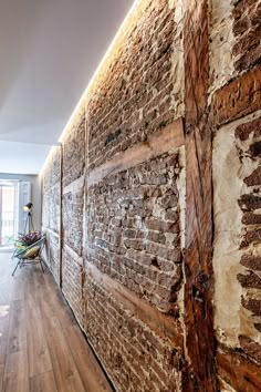 a brick wall in an apartment with wood flooring