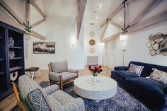 a living room with couches, chairs and a coffee table in it's center