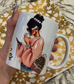 a hand holding a coffee mug with an image of a woman wearing jewelry on it