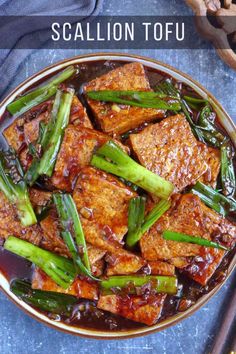 tofu and asparagus stir fry in a brown sauce on a plate with chopsticks