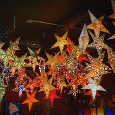 colorful paper stars are hanging from the ceiling