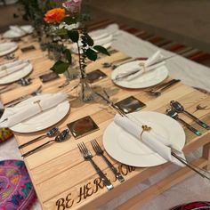 the table is set with white plates and silverware, flowers in vases, and napkins