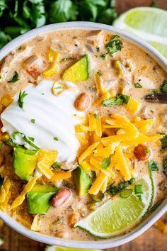 a white bowl filled with tortilla soup topped with sour cream and avocado