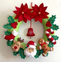 a christmas wreath with teddy bears and poinsettis hanging from it's side