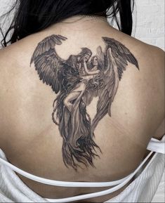 a woman with an angel tattoo on her back