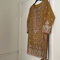 Worn Only Once In Excellent Condition This Suit Comes With A Fully Embroidered Kameez Which Is Organza Based Shalwar Also Has Some Embroidery On The Bottom The Dupatta Is Also Organza Based And Has A Beautiful 2 Side Pallu And 2 Side Small Boarder Indian Pakistani Designer Gold Kurta With Chikankari Embroidery, Designer Long Sleeve Yellow Kurta, Designer Yellow Kurta With Chikankari Embroidery, Festive Yellow Designer Kurta, Elegant Yellow Churidar, Festive Designer Yellow Kurta, Mustard Anarkali Kurta For Diwali, Festive Mustard Anarkali Kurta, Elegant Yellow Straight Kurta