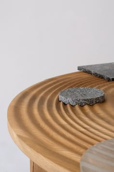 a wooden table topped with a stone slab next to a black piece of wood on top of it