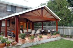 a covered patio with potted plants on the side and an awning over it