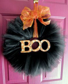 a door hanger with the word boo on it and a bow attached to it