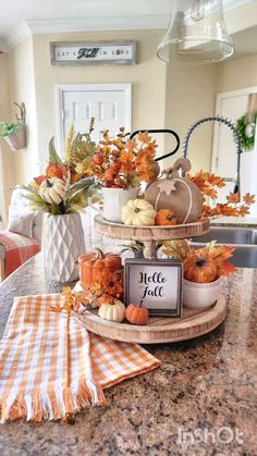 a kitchen counter topped with pumpkins and other fall decorations on top of a wooden tray