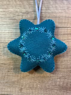 a blue star ornament hanging on a wooden table