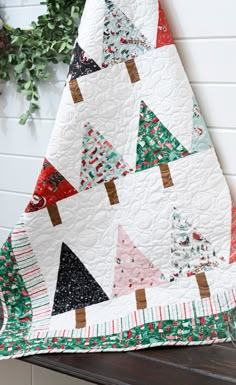 Try this Easy Beginner Friendly Winter Pines Quilt Tutorial! This quilt is mighty pine! Piece a beginner-friendly Winter Pines Quilt using the Missouri Star pattern and cheery Twas fabrics by Riley Blake designer Jill Howarth. Winter Pines Quilt Pattern, Mini Christmas Quilts, Christmas Quilt Fabric, All Wrapped Up Quilt Pattern Free, Christmas Quilt Patterns Easy, Christmas Tree Quilt Patterns Free Printable, Simple Christmas Quilts, Easy Christmas Quilts For Beginners, Layer Cake Christmas Quilt Patterns