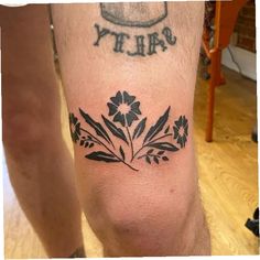 a man with a tattoo on his leg that says, dirty and has flowers in it