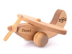 a wooden toy airplane with the name daniel written on it's wing and wheels