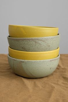 three yellow and gray bowls stacked on top of each other